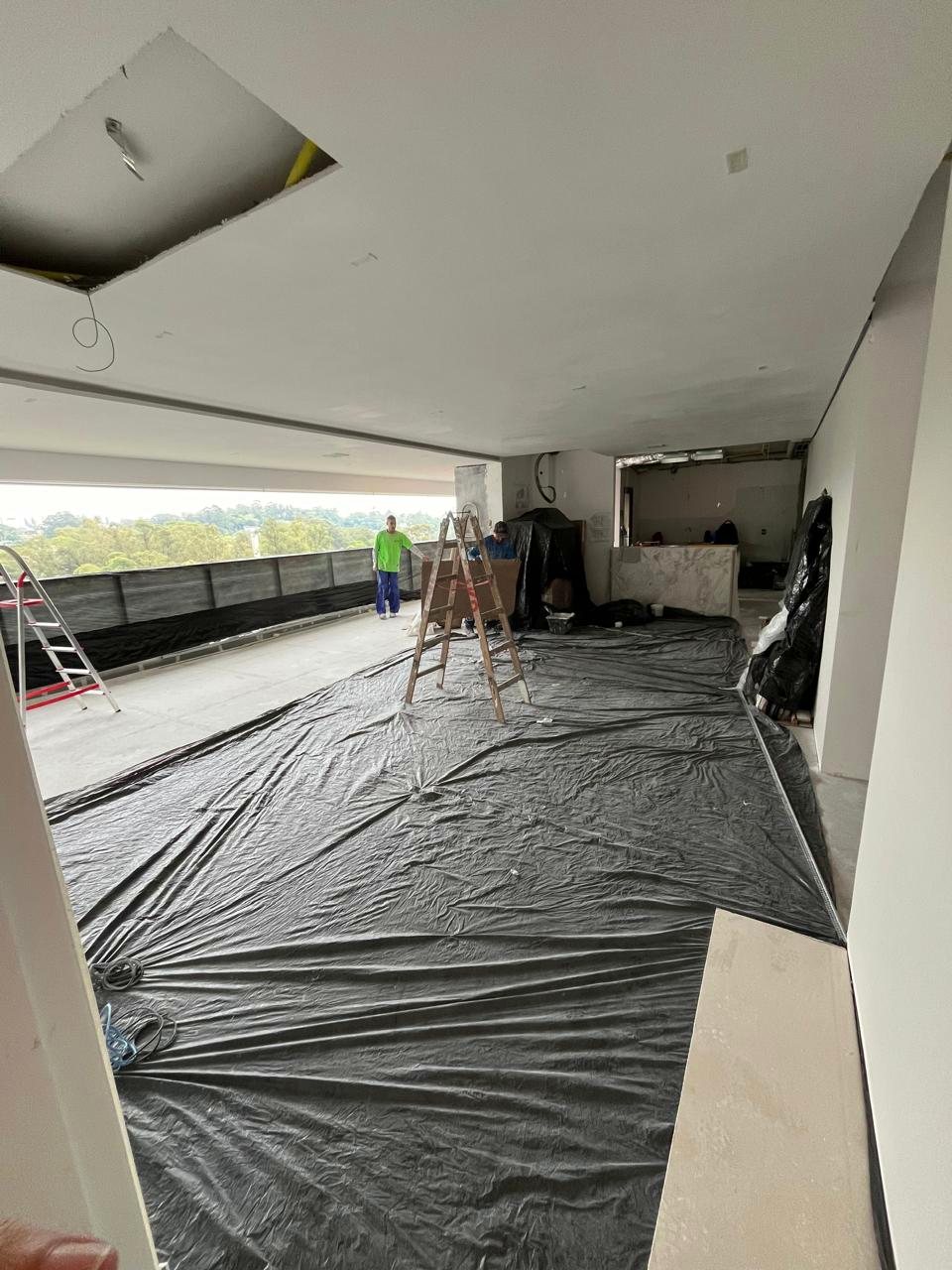 Apartamento em reforma com o piso coberto por lona